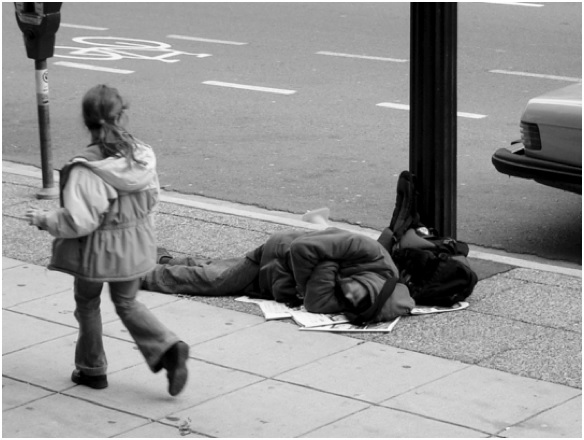 A young girl passing by a sleeping homeless man (Black, 2010).