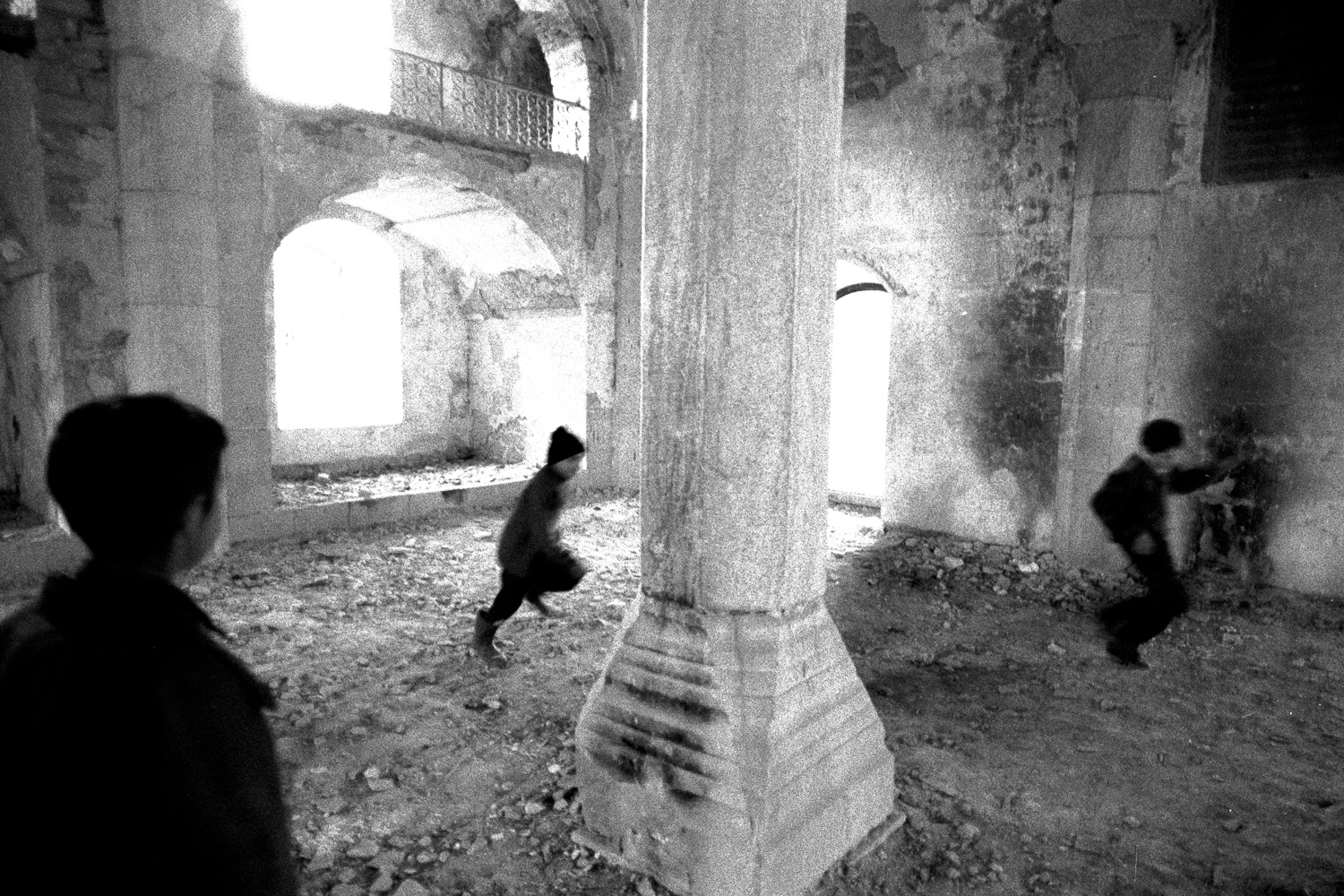 Photo by Ara Oshagan. Kids play inside of a burned out mosque. Shushi, Nagorno-Karabakh,1999. 
