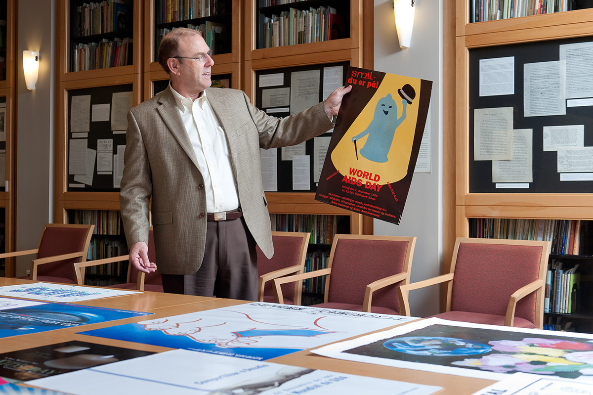 Michael Gottlieb, MD ‘73, examines AIDS awareness posters that are part of a collection of more than 8,000 posters in the University's Rare Books and Special Collections department. (University photo / Brandon Vick)