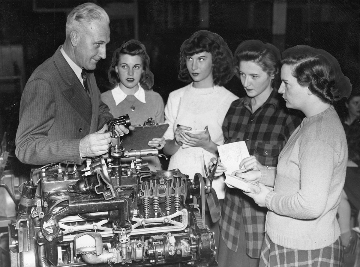 From the original photo caption: “UR Women Intrigued By Motor Mechanics: (left to right): Prof. Harold De May, who is instructor in the newly organized motor mechanics course at the Women’s College of University of Rochester, shows Frances Chamberlain, Jacqueline Briggs, Dorothy Barry and Mary Elizabeth Garravan the rudiments of a motor engine at the first meeting this week of the course sponsored by the War Activities Board of the Women’s Campus.