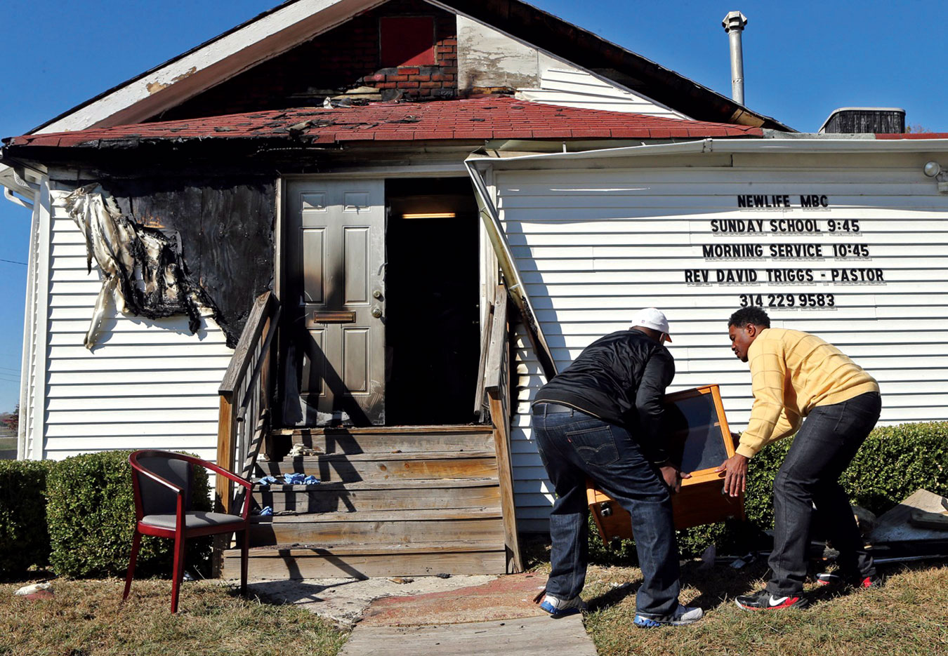 On the Sunday after New Life Missionary Baptist Church was set on fire, the service was held outside. Afterward, Deacon Clinton McMiller and Pastor David Triggs carried a cabinet back inside.