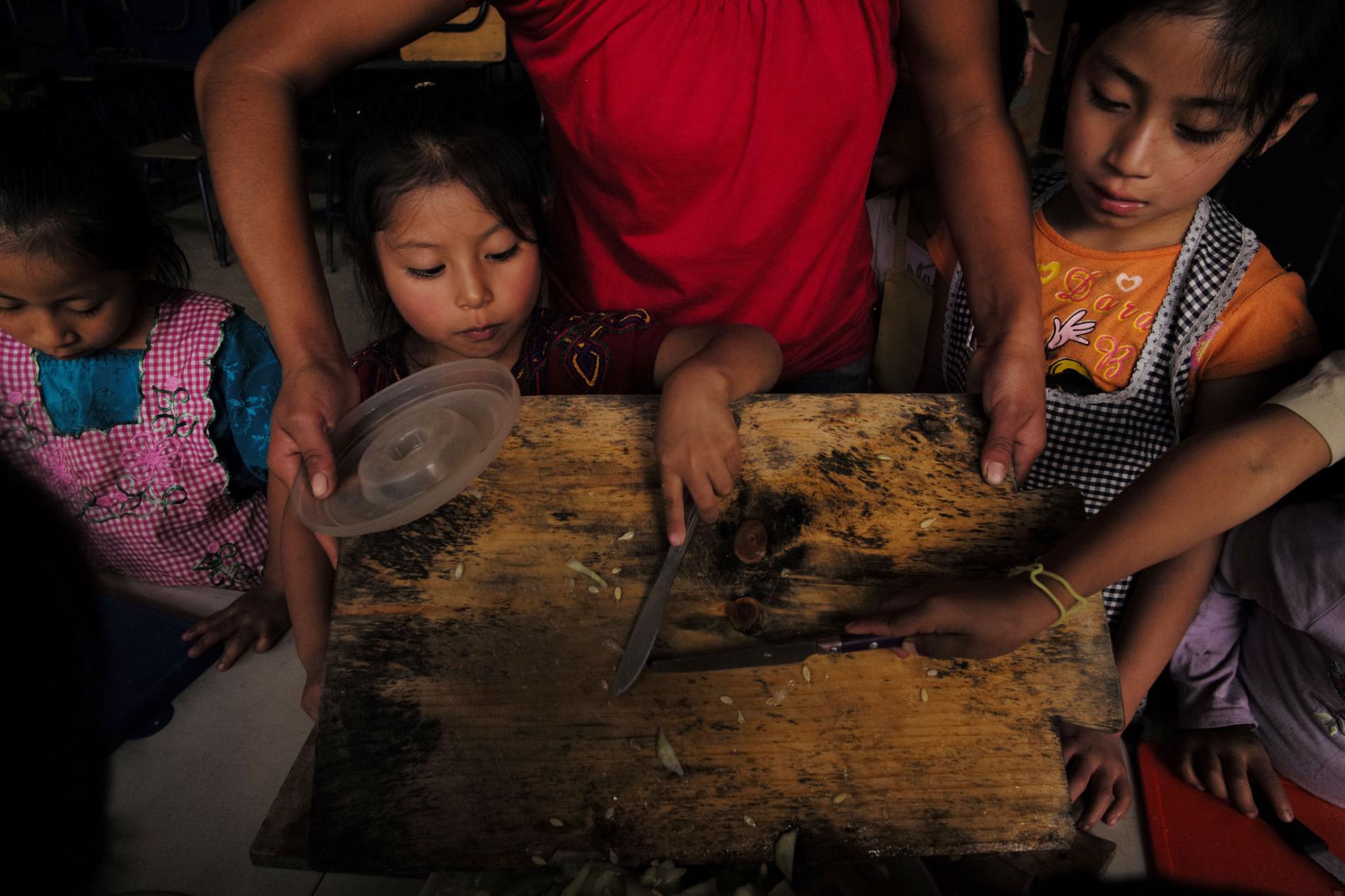 At Paso a Paso School in San Antonio Aguas Calientes, the kids make lunch with a stove made by the Ecocomal company, whose co-founder, Ana Luisa Herrera, also started the school. Safe, smokeless cookstoves promote education—because they help protect children’s health. Image by Lynn Johnson. Guatemala, 2017.