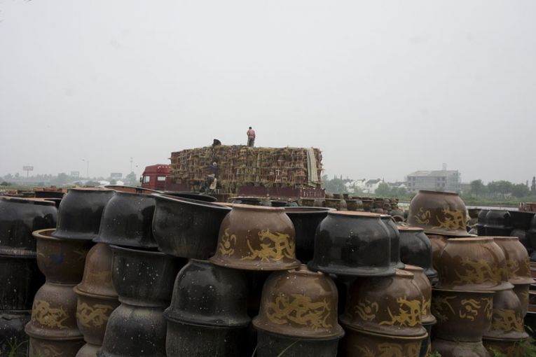 Yixing is the center of the glazed ceramics industry, which makes products such as these pots ready for shipment in Dingshu. Waste dumped by the industry is a major contributor to the area’s soil pollution. Image by Wu Di. China, 2014.