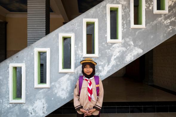Nurul Atphia, 9, stands in front of stairs at the mosque in Pesarean, a historic metalworking village that has been contaminated by backyard lead battery smelting. Image by Larry C. Price. Indonesia, 2016.