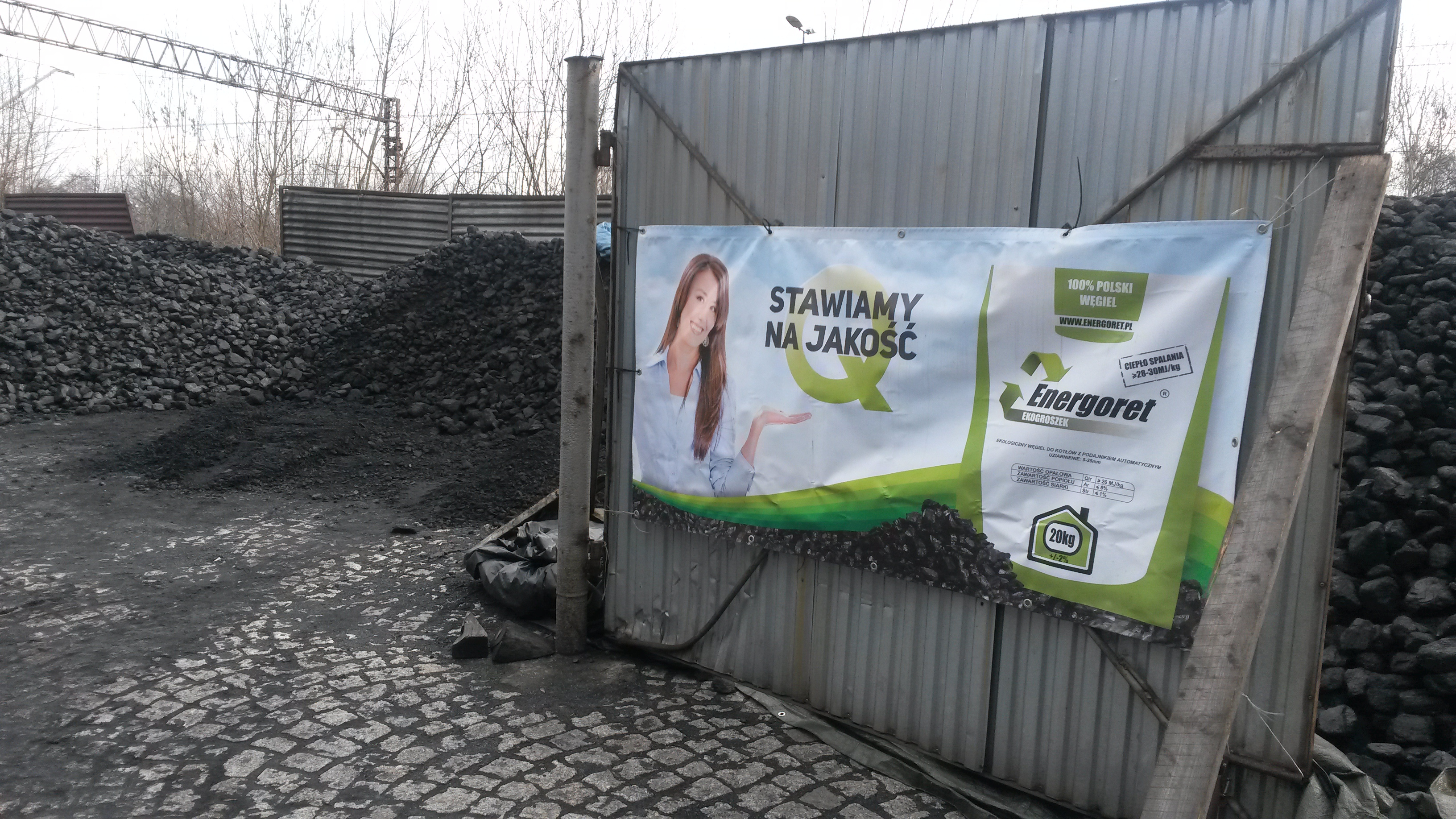 “Quality is our priority,” says the banner at Grzegorz Rumin’s coal lot. Krakow residents breathe the worst air in Poland, in part because some burn coal all winter in low-tech home stoves. Image by Beth Gardiner. Poland, 2014.