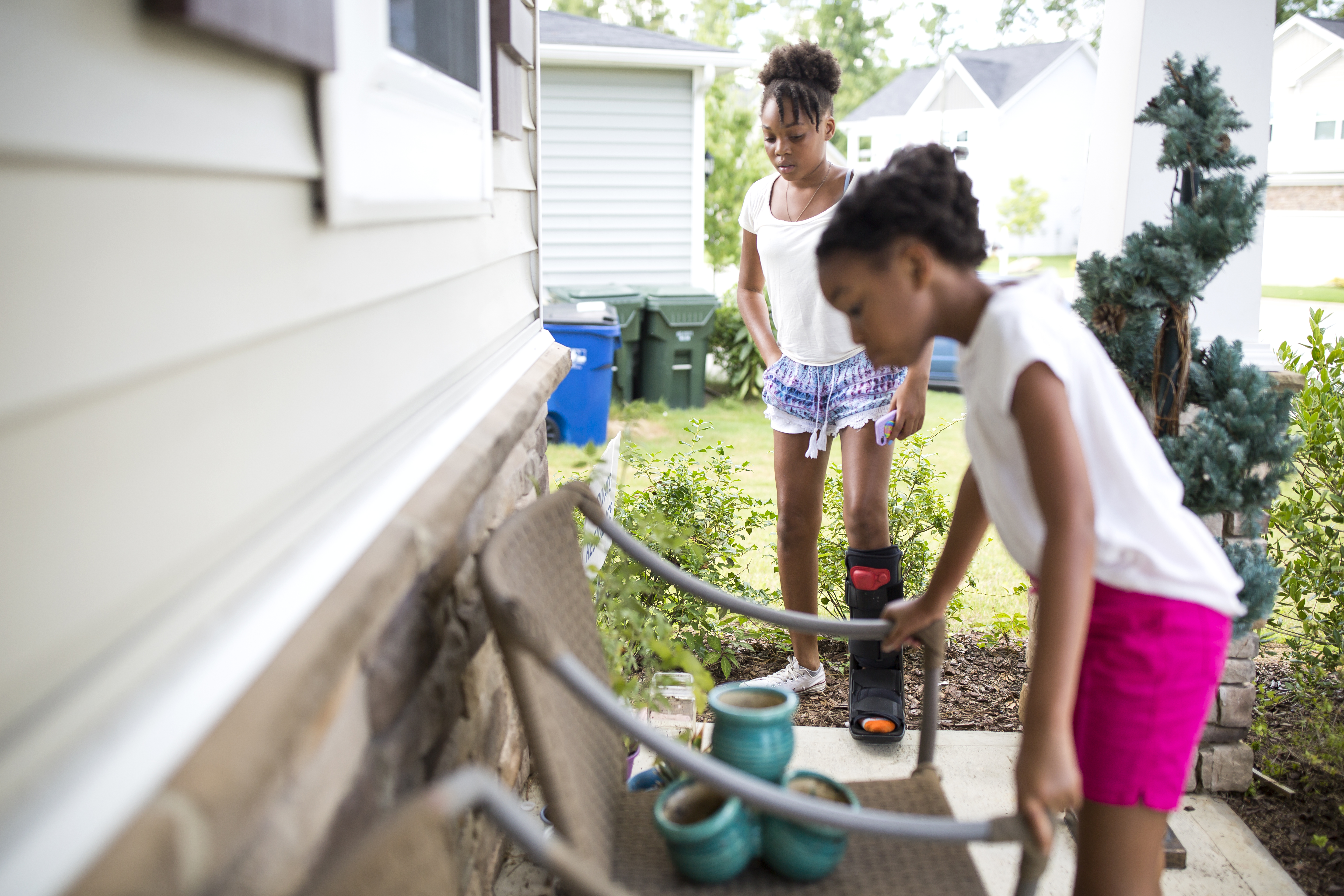 Kaiden, left, and Karisma, right, inspect their small garden at home during summer break. They found tomato plants in the woods behind their house and bought some spinach and flower seeds from Walmart. Kaiden feels that “the garden is a little homely and needs some maintenance.”