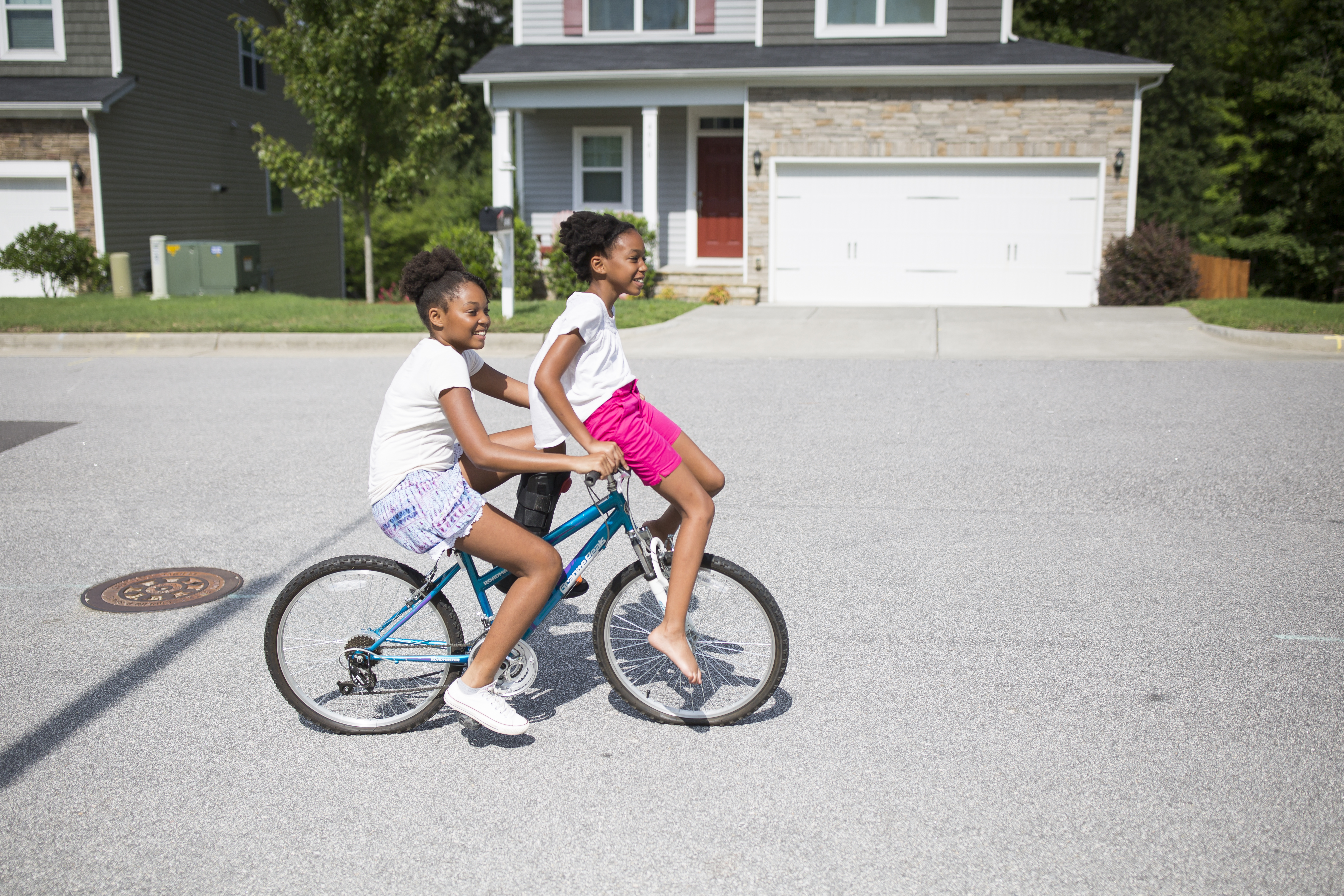 Kaiden gives her sister Karisma a ride on her bike as they play at home during summer break in Raleigh. While their mom Ayeisha Owens is at work, they stay at home with their great grandmother. They make up games and dance routines and read books, but their mom still worries about them being bored. 