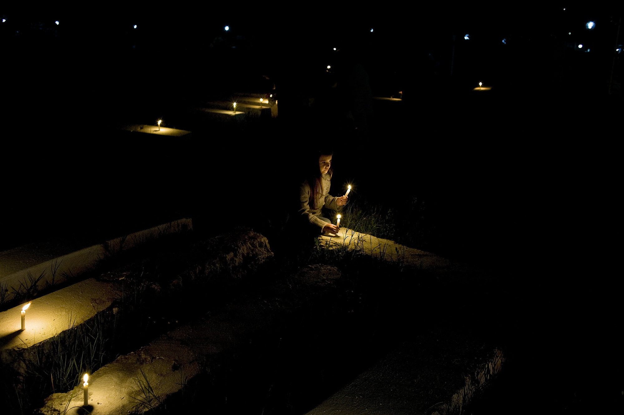 A young girl places candles on gravestones at the Jewish Cemetery of Ouazanne during the hilloula or pilgrimage of Rabbi Amran Ben Diwan. (Photo: Aaron Vincent Elkaim)